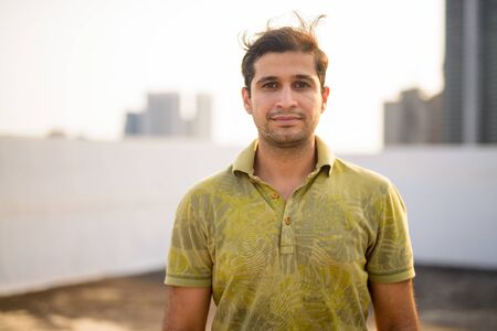 Young handsome Persian man against view of the cityの写真素材