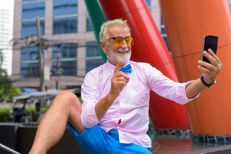 Handsome senior tourist man exploring the city of Bangkok, Thail