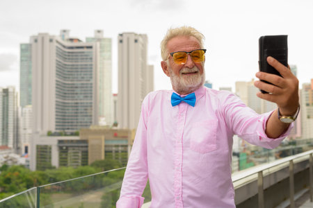 Handsome senior tourist man exploring the city of Bangkok, Thail