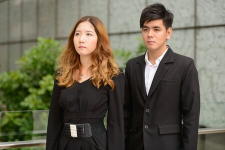 Young Asian business couple thinking together at the parkの写真素材