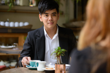 Young Asian business couple talking together at the coffee shopの写真素材
