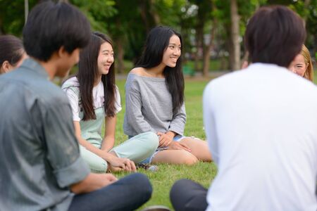 Happy young group of friends having fun together at the parkの写真素材