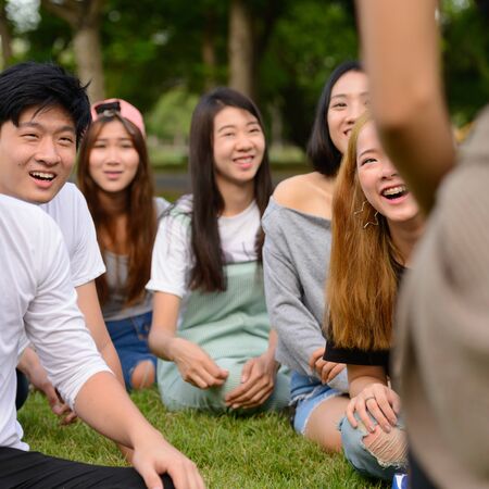 Happy young group of friends having fun together at the parkの写真素材