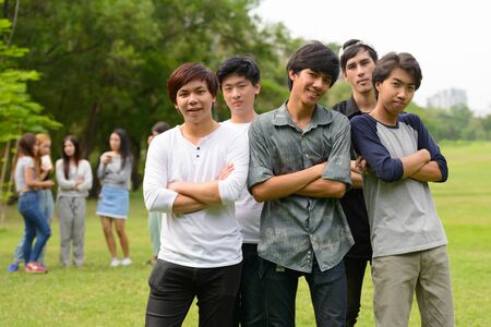 Happy young group of friends hanging out together at the parkの写真素材