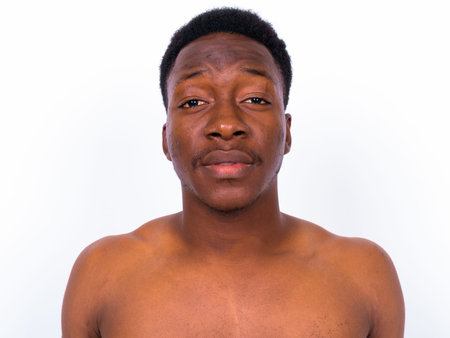 Young handsome African man shirtless against white background