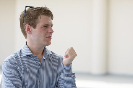 Young handsome blond businessman thinking in the streets outdoors