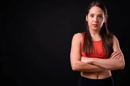 Young multi ethnic beautiful woman ready for gym against black backgroundの写真素材
