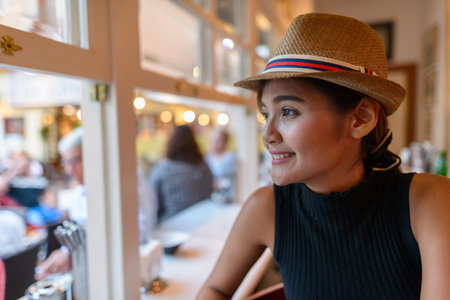 Closeup of happy young Asian tourist woman looking outside the windowの写真素材