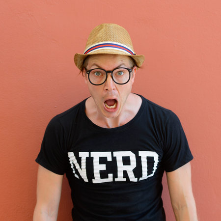 Portrait of young nerd tourist man looking shocked