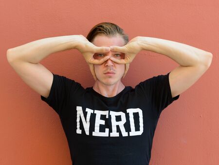 Portrait of young handsome nerd man posing as superheroの写真素材