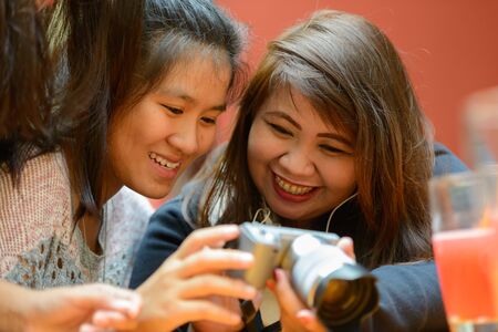 Group of young Asian women as friends hanging out together outdoorsの写真素材