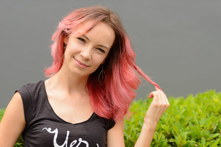 Face of beautiful woman with pink hair outdoors