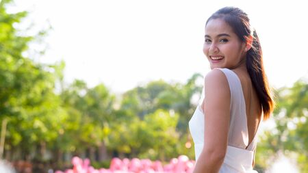 Happy young beautiful Asian woman relaxing outdoorsの写真素材