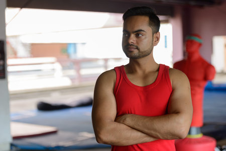 Young bearded Indian man thinking at the boxing gymの写真素材