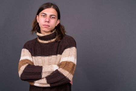 Young androgynous man with long hair ready for winterの写真素材