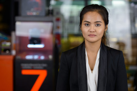 Young beautiful Asian businesswoman with hair tied outdoors