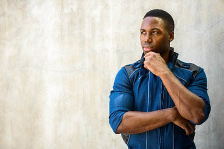 Portrait of young handsome African man thinking