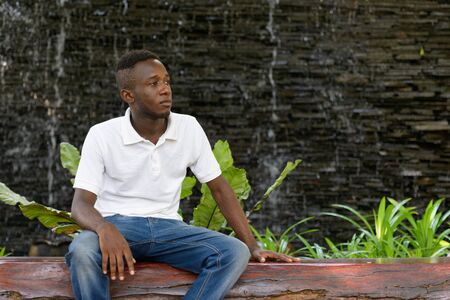 Portrait of young African man thinking in the city outdoorsの写真素材