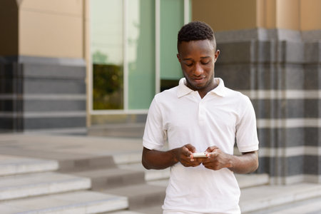 Portrait of young African man using phone in the city outdoors