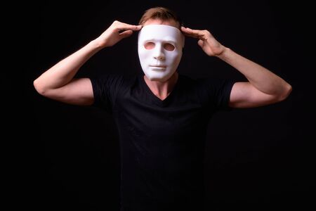 Portrait of young man wearing white maskの写真素材