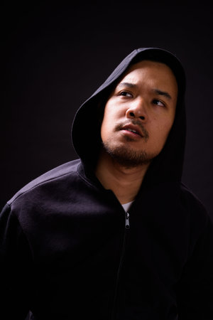 Portrait of young Asian man with hoodie thinking