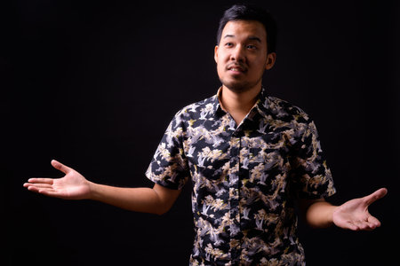 Portrait of young Asian man with arms raised