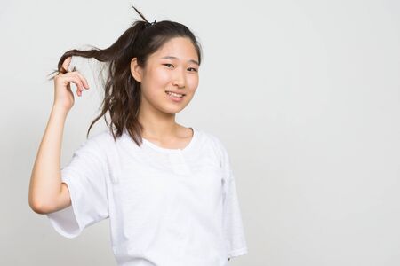 Portrait of happy young beautiful Asian woman with hair tiedの写真素材