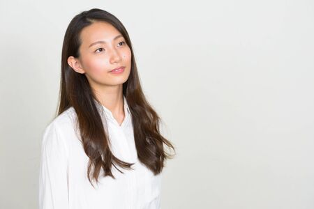 Portrait of young beautiful Asian businesswoman thinkingの写真素材