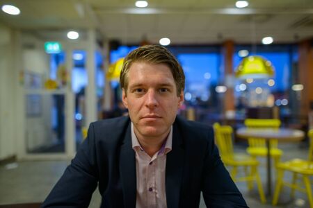 Young handsome businessman sitting inside the restaurantの写真素材