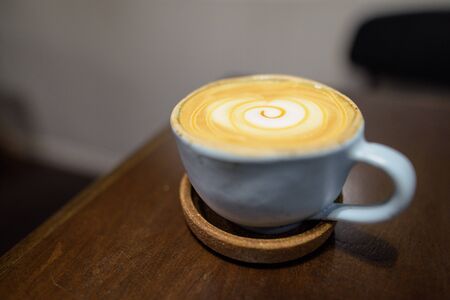 Cup of cappuccino coffee on wooden tableの写真素材