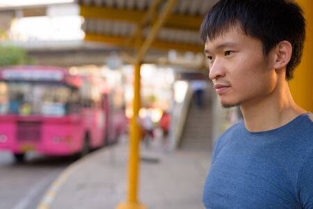 Portrait of young Asian man at the bus stopの写真素材