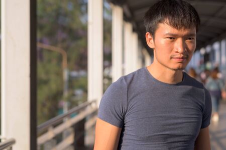 Portrait of young Asian man exploring the cityの写真素材