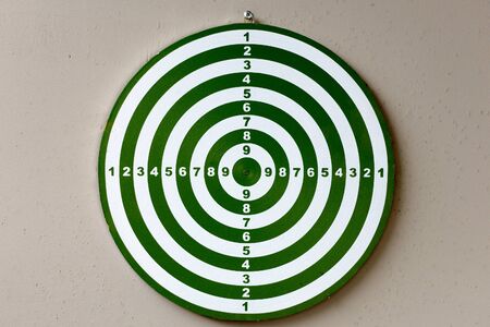 Portrait of dartboard with numbers against concrete wallの写真素材