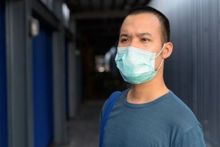 Face of young Asian man in the city outdoors