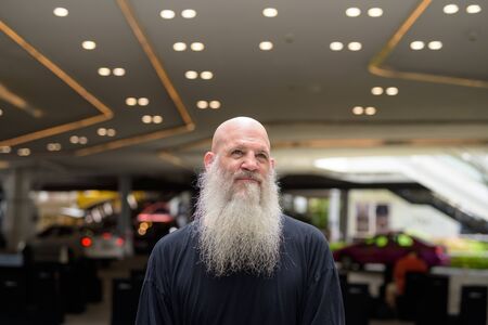 Mature handsome bald bearded man thinking in the city outdoorsの写真素材