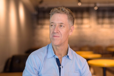 Face of mature businessman thinking at the coffee shop