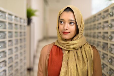 Young beautiful Indian Muslim woman checking the mailの写真素材
