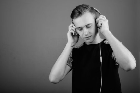 Young handsome man with blond hair listening to music