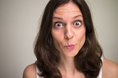 Face of beautiful woman with brown hair looking shockedの写真素材