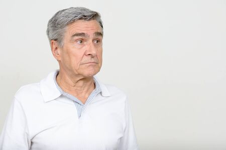 Portrait of handsome senior man thinking and looking awayの写真素材