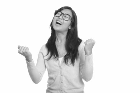 Happy young beautiful Asian nerd woman getting good newsの写真素材