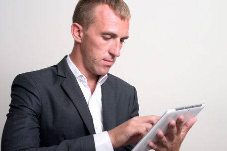 Face of businessman in suit using digital tablet