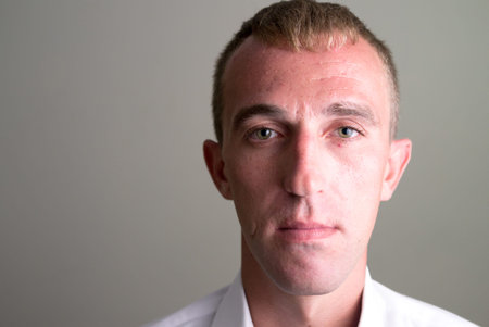 Face of businessman with blond hair looking at camera
