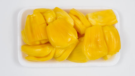 Ripe jack fruit slices against white background