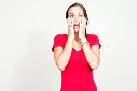 Portrait of young beautiful woman with brown hair looking shocked
