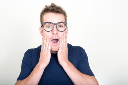Portrait of handsome man with eyeglasses looking shocked