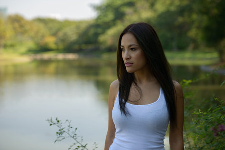 Portrait of beautiful Asian woman thinking at the park outdoors