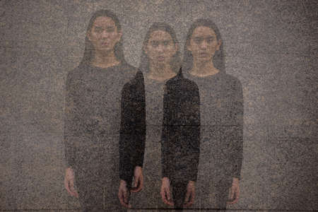 Young Asian man with long hair in the city with multiple exposure effectの写真素材