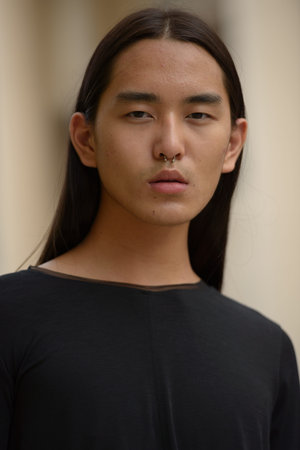 Face of young Asian man with long hair in the cityの写真素材