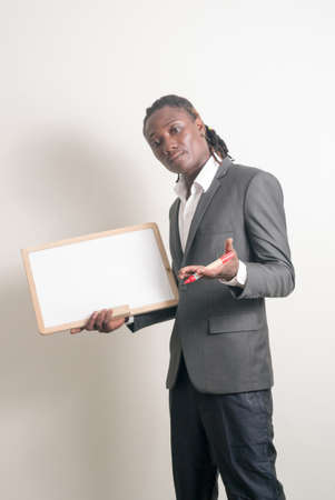 Young handsome African businessman with dreadlocks holding white boardの写真素材